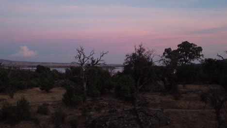 Rising-aerial-shot-of-Embalse-Santillana,-Sierra-de-Guadarrama-during-a-colourful-sunset