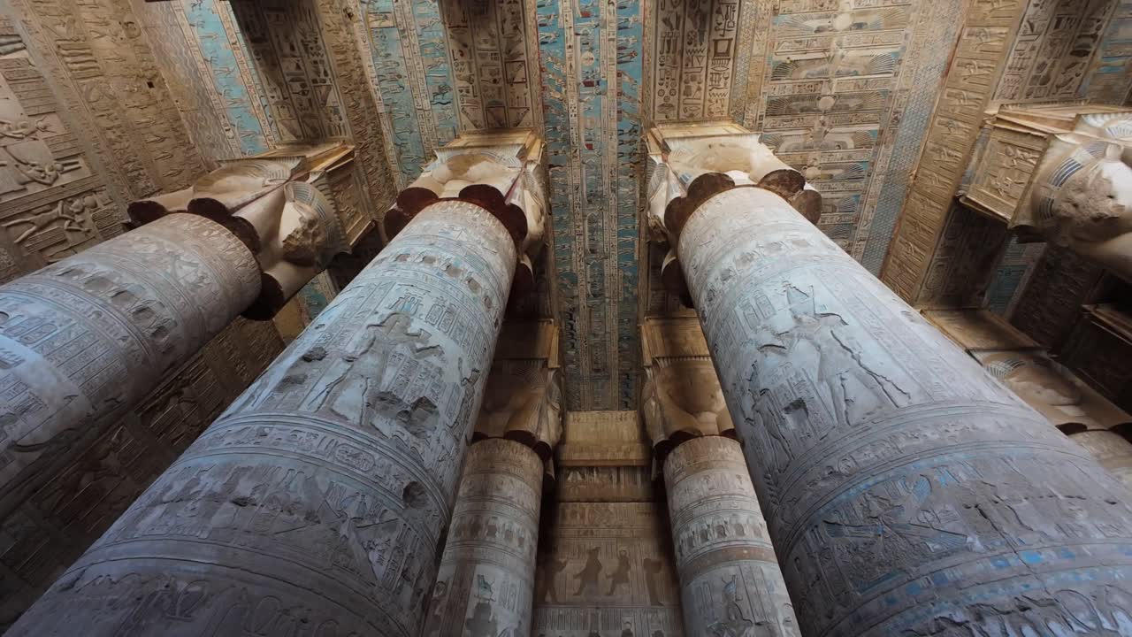 Painted columns and ceiling inside Dendera Temple of Hathor in Egypt in tilt up video