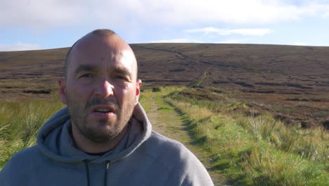 Irish-Man-Annoyed-By-Wearing-Facemask,-Removes-The-Mask-From-His-Face-And-Throws-Into-The-Wicklow-Mountains-In-Ireland---medium-close-up