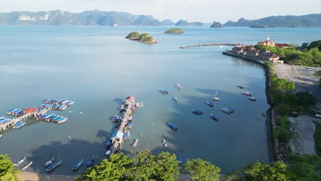 vista aérea del muelle de langkawi, malasia, rodeado de barcos, agua y colinas verdes bajo un cielo despejado