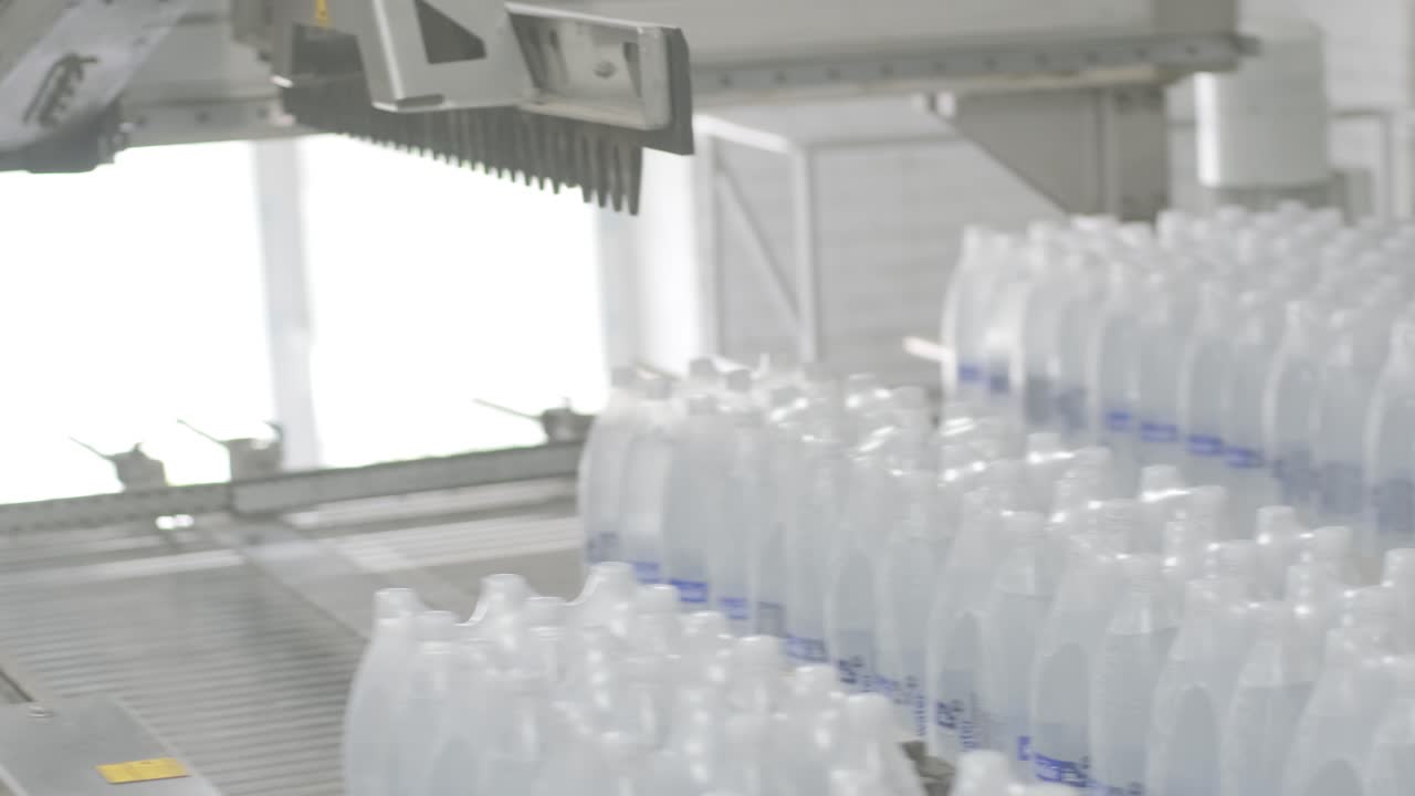 máquina moderna de ataduras y transporte para la línea de envasado en la planta de bebidas