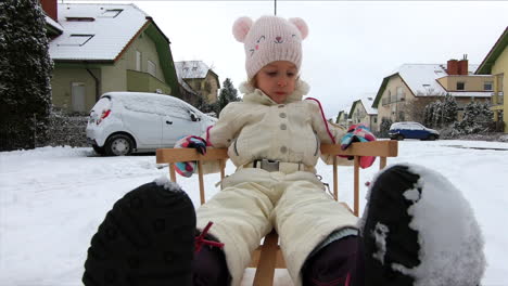 Ein-Kleines-Mädchen-Ist-Auf-Einem-Schneeschlitten