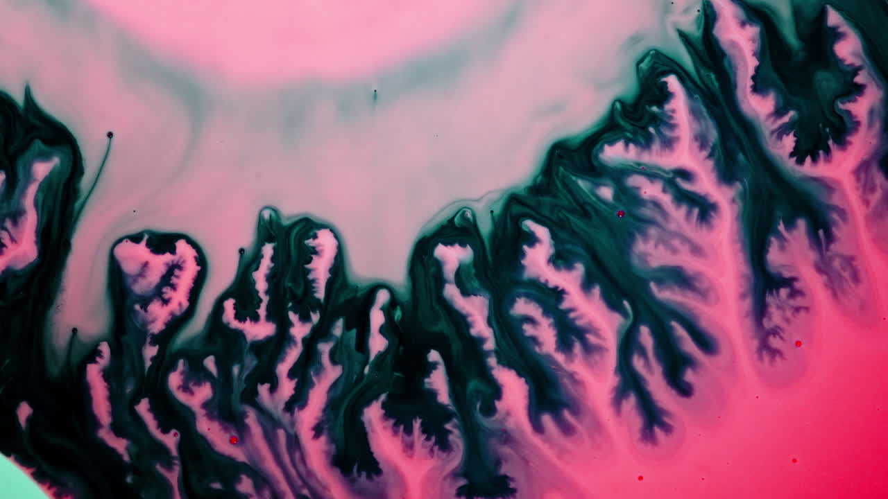 Substances mixing, macro shot showing vibrant ink swirls blending together in liquid
