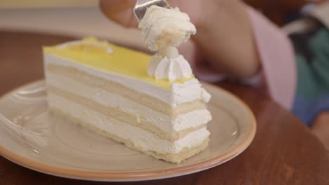 closeup of a slice of yellow cake with whipped cream and white chocolate