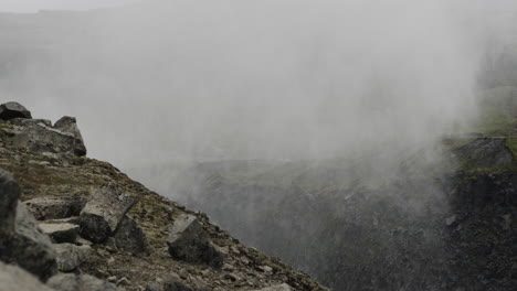 Filmische-Kamerafahrt-über-Die-Dettifoss-Wasserfälle,-Während-Touristen-Den-Nebel-Bewundern,-Der-Aus-Den-Schluchten-Hunderte-Von-Fuß-Unter-Den-Wasserfällen-Kommt