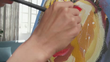 un hombre artista asiático con un pincel de colores mixtos y pintando la cara de una chica en el lienzo