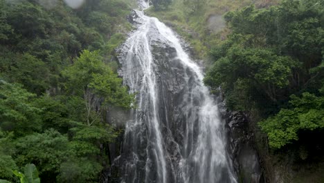 lush efrata waterfall cascading down rocky cliff surrounded by green foliage near lake toba