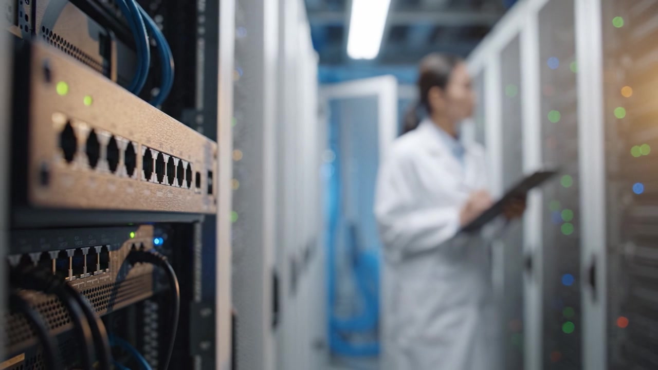 Technician in Lab Coat Monitoring Data Center Equipment and Networks, Ensuring Proper Functionality in a High-Tech Server Environment with Active Connections