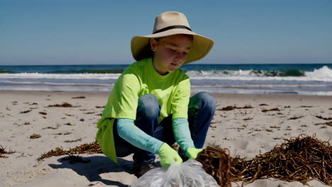 child cleaning up beach litter