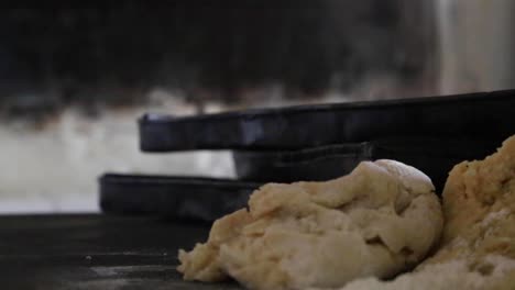 hands kneading dough and baking bread in a rustic oven