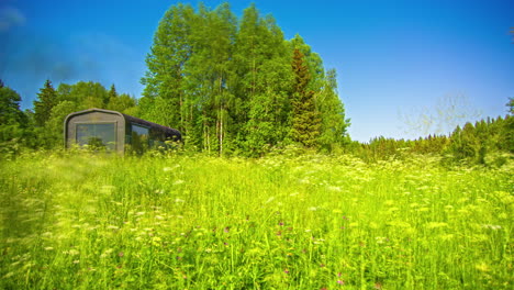 Ganztägiger-Zeitraffer-Eines-Campinganhängers-In-Einem-Feld-Von-Wildblumen-Im-Frühling