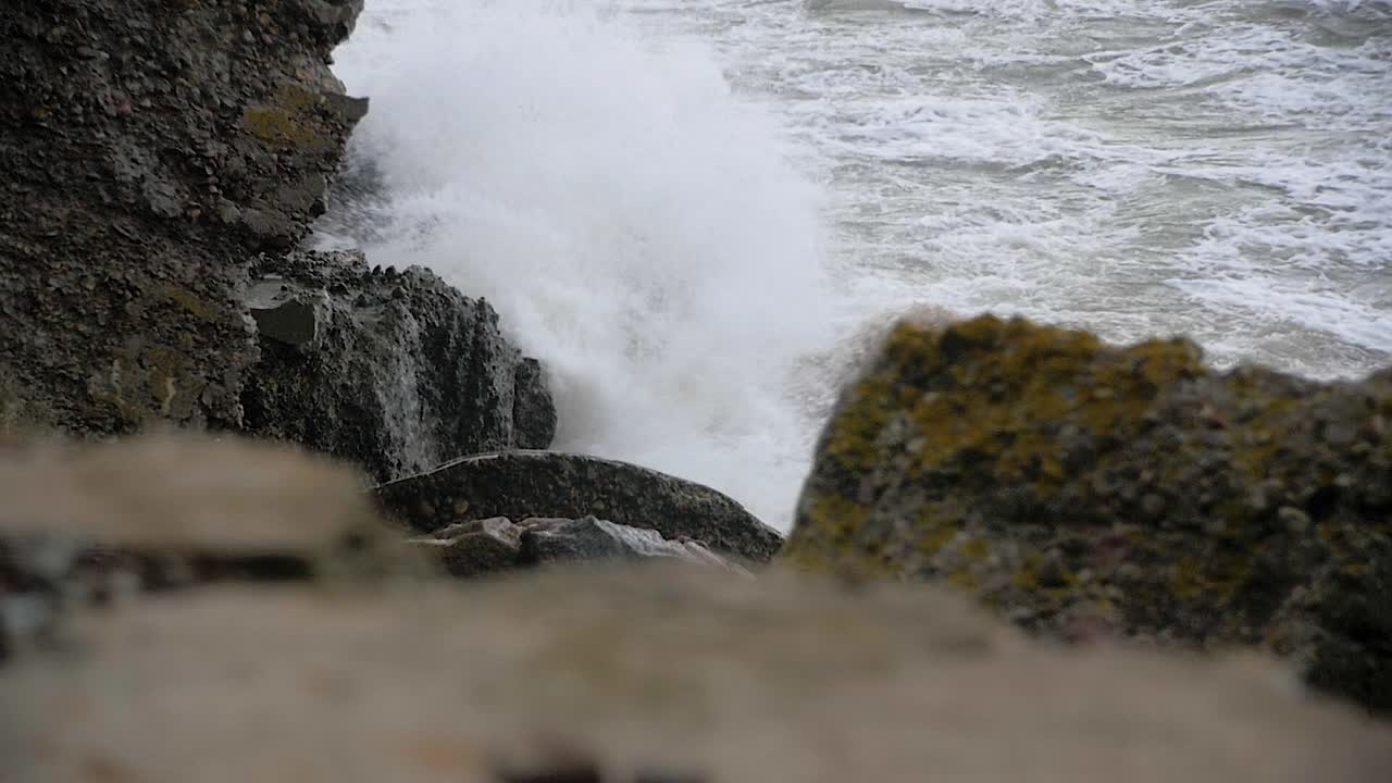 폭풍우 치는 날씨에 슬로우 모션으로 버려진 콘크리트 해안 방어 건물 폐허를 강타하는 큰 파도