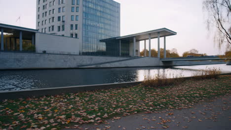 man walking along a riverside path in autumn