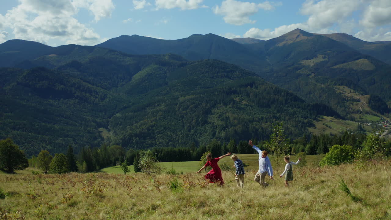 счастливая семья танцует и бежит по лесу на фоне голубого неба.