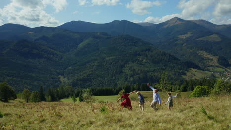 happy family dancing and running through the forest against a blue sky