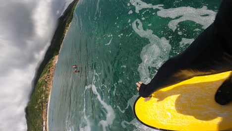 vertical pov of surfer surfing on tropical ocean wave