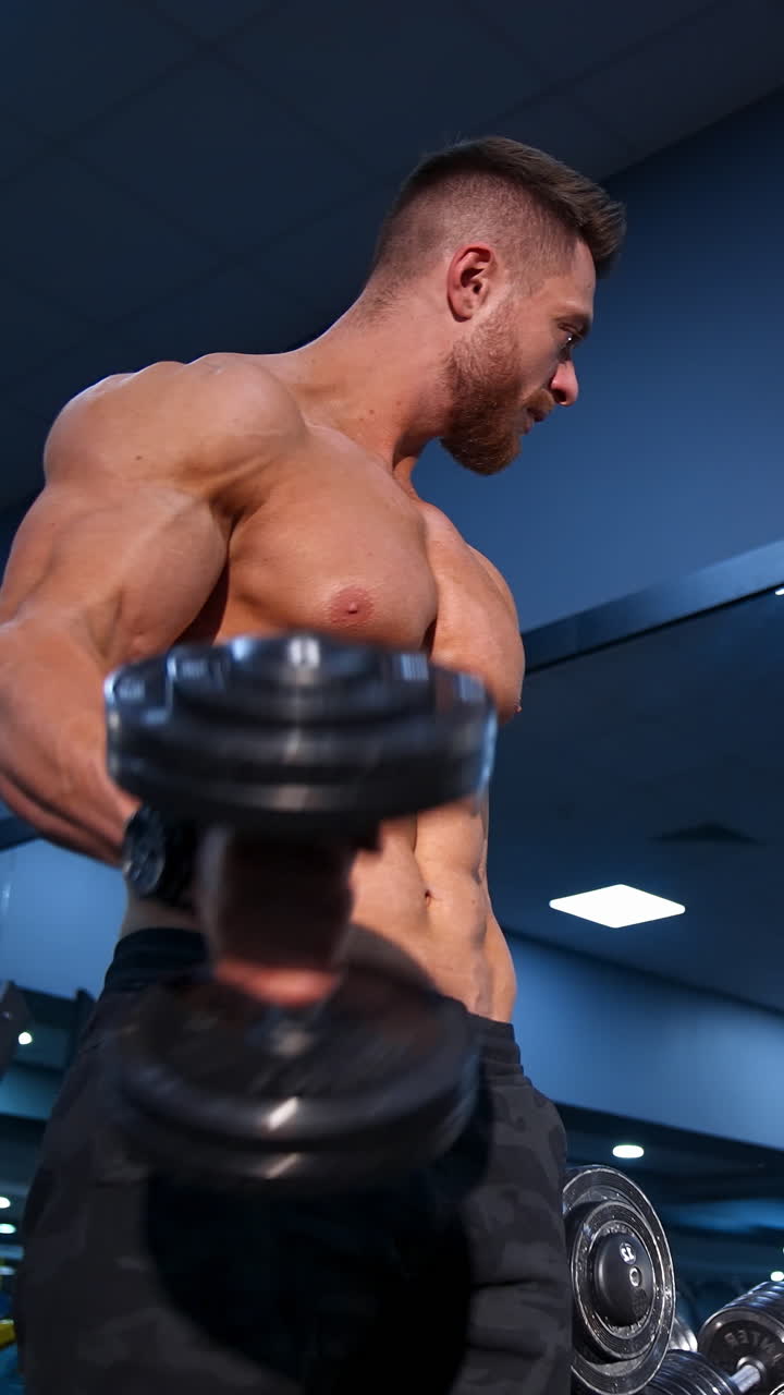 Uomo che si allena con i manubri in palestra