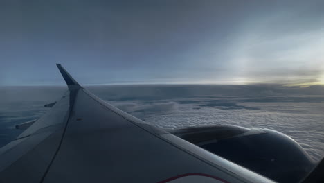 vista por la ventana del avión del paisaje nublado al amanecer o al atardecer