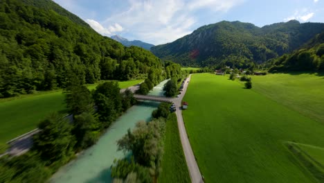 drone fpv volando sobre un río con agua turquesa rodeado de montañas verdes de austria