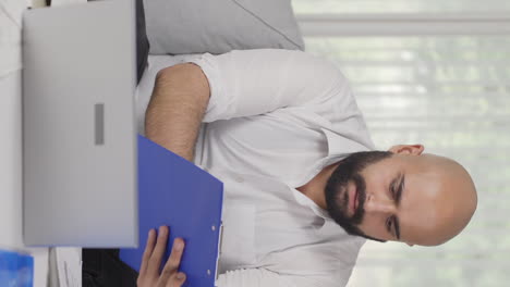 vertical video of home office worker man reviewing paperwork files.
