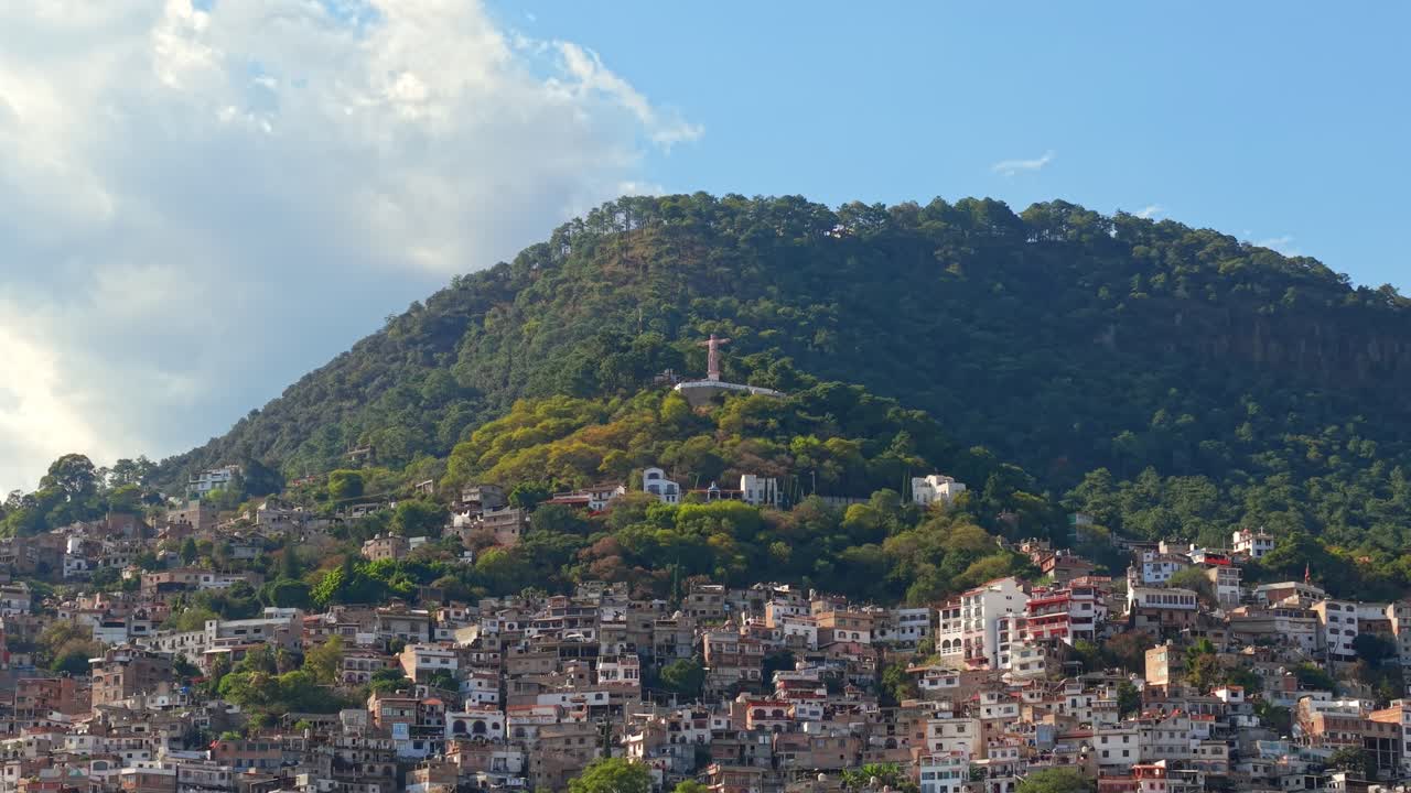 Vista aerea delle case residenziali sulle pendici del colle Atachi, quartiere Casahuates, con il Cristo Monumentale di Taxco in cima, Guerrero, Messico.
