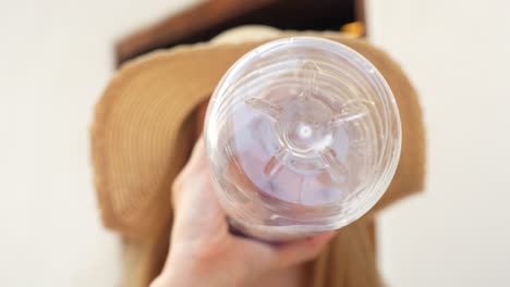 Young-female-tourist-hydrates,-drinking-water-from-plastic-bottle-on-hot-day