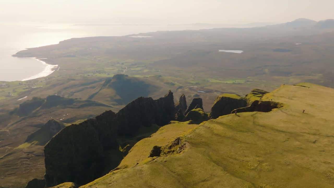 Aerial drone footage of the dramatic mountain landscapes on the Isle of Skye, Scotland. Sweeping panoramic views of majestic peaks, green valleys, and wild nature. Quiraing walk