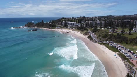 Drone-Volando-Sobre-Una-Playa-De-Surf-Rompiendo-Olas-Y-Surfistas-Debajo