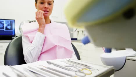 Scared-female-patient-looking-at-dental-tools