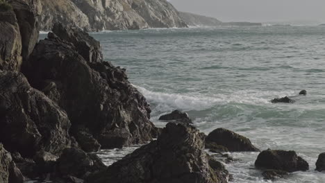 Close-up-shot-of-sharp-dark-rocks-at-the-coast