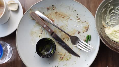 empty plate with utensils and leftovers