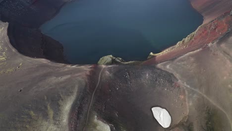 toma aérea desde arriba hacia abajo dentro del cráter ljotipollur con lago volcánico en islandia