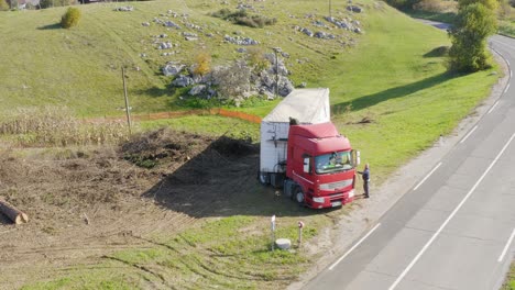 Aerial-of-heavy-loaded-truck-parked-by-the-traffic-road