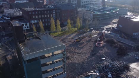 demolished multi storey car park concrete construction debris in town regeneration aerial view across demolition site left