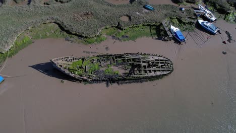 Shipwreck-Covered-With-Moss-Near-Salt-Marshes-In-Tollesbury-Marina,-Essex,-United-Kingdom