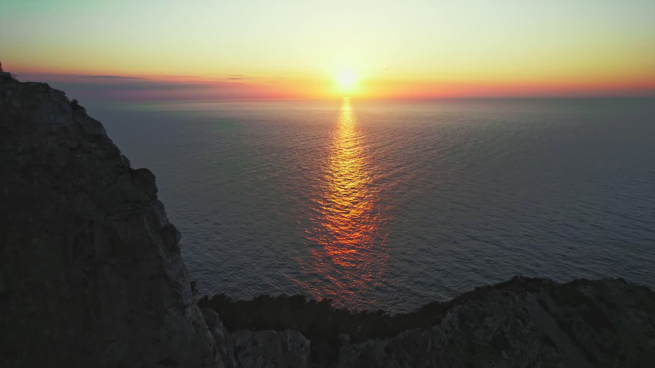toma de drones de 4k de la puesta de sol sobre el océano en la costa de ibiza en las islas baleares