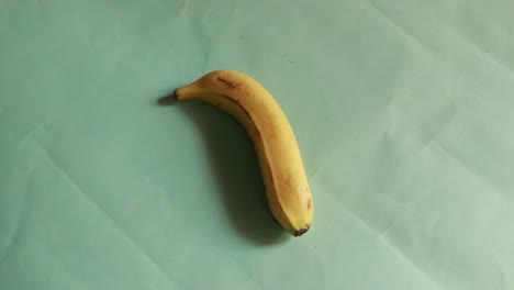 바나나는 녹색 배경에 고립된 원으로 회전합니다