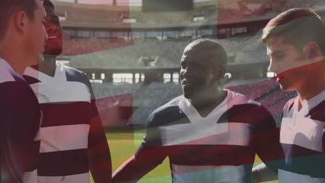 Animation-of-flag-of-switzerland-over-diverse-male-rugby-players-talking-at-stadium