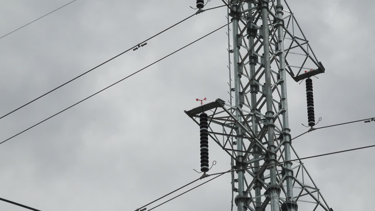 Electricity Pylon and Weather Vane in Strong Winds