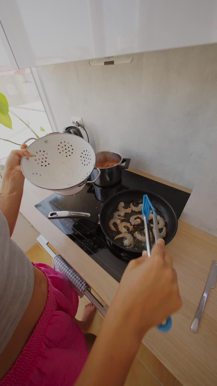 Person cooking shrimp in a kitchen