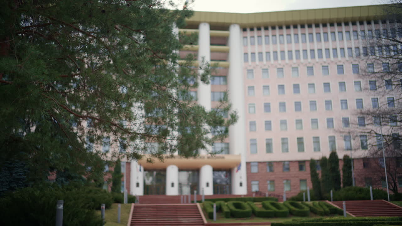 Kişinev, Moldova - 12 Mart 2026: Sütunlar, pencereler ve peyzajlı yeşilliklerle Parlamento binasının dış görünümü