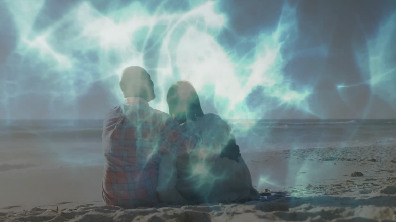 Couple sitting on beach gazing at ocean, with animated blue light patterns showing technology theme