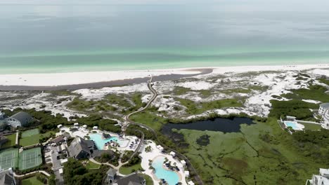 girando a la derecha visión amplia del lado del océano, edificios, piscinas, canchas de tenis, lago, bosque, cielo azul al otro lado de la calle de la prominencia en 30a florida y el club de sonido de agua