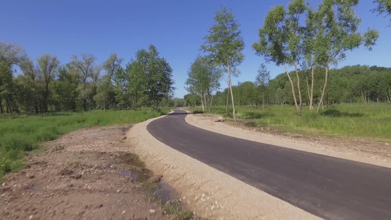 vuelo bajo del dron aéreo hacia la pasarela del parque sinuoso