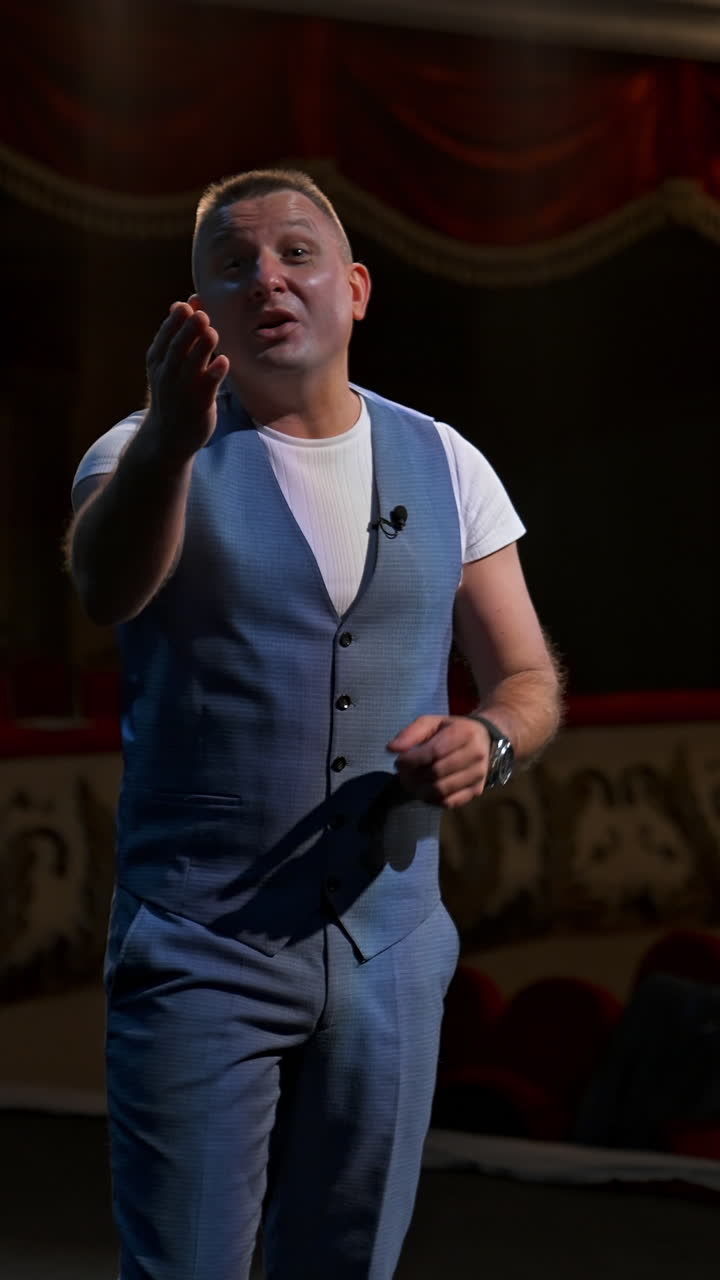 Performer points on a watch from stage and announces performances in theater. Beginning of theater season after covid-19. Vertical video