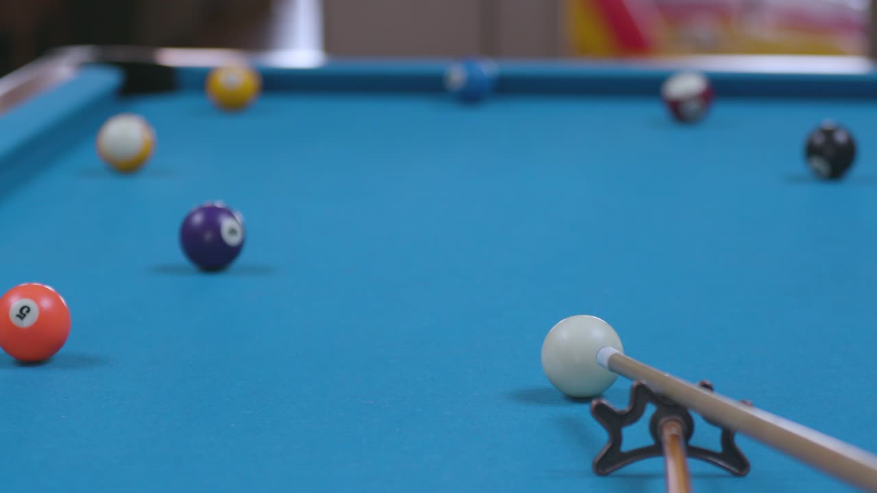 Man Sinking Shot in Corner Pocket on Blue Billiards Table with Bridge