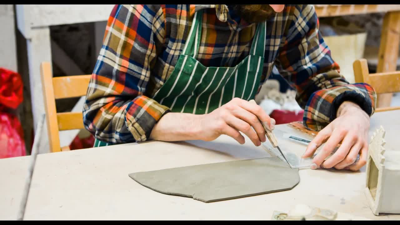 Male potter molding a piece of flat clay