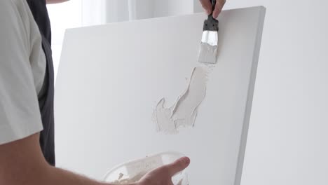 applying texture paste to a canvas for art
