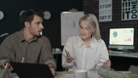 una pareja de negocios discutiendo informes financieros.