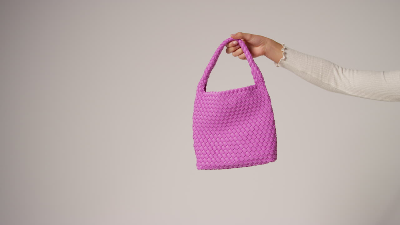 primer plano de una mujer influyente en las redes sociales produciendo contenido generado por el usuario sosteniendo una bolsa de moda púrpura 3